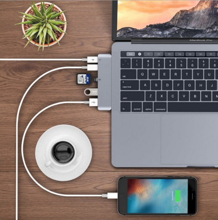 Hub connected to a MacBook, showing SD card and USB drives in use
